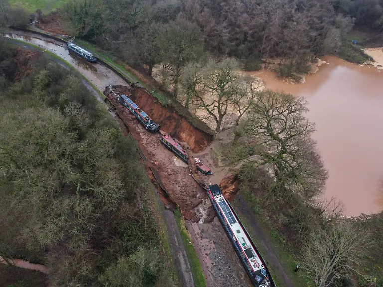 Blick-auf-einen-Erdrutsch-in-Whitchurch-durch-das-grosse-Mengen-Wasser-in-das-Chemiegebiet-in-Whitchurch-gelangen-Rettungsdienste-hatten-den-Grossunfall-gemeldet-nachdem-mehrere-Meldungen-bei-ihnen-eingingen-Zehn-Menschen-wurden-in-Sicherheit-gebracht-nachdem-ein-50-Meter-langes-Sinkloch-in-einen-Kanal-in-Shropshire-durchbrochen-und-mehrere-schmale-Boote-auf-Grund-gesetzt-hatte