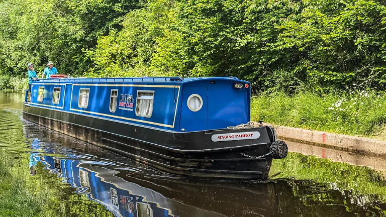 19-06-2025-Lllangollen-Schmalboote-auf-dem-Llangollen-Kanal-in-Wales-UK-umgeben-von-ueppigem-Gruen-und-ruhigem-Wasser