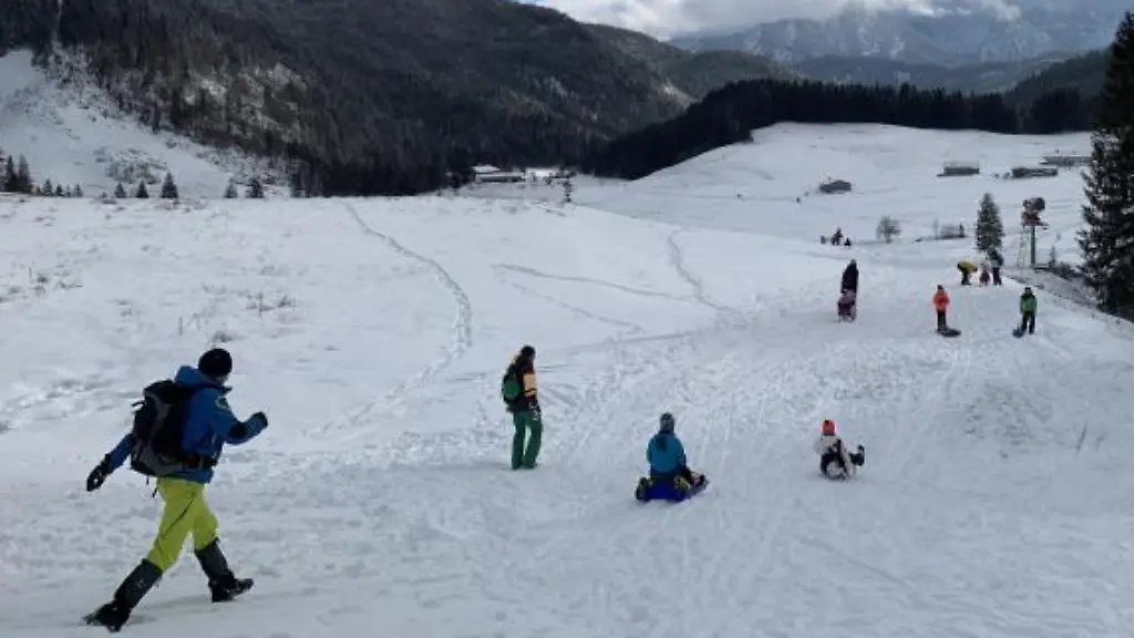 Rodler-und-Wanderer-sind-im-Skigebiet-Spitzingsee-unterwegs