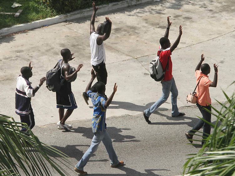 Zivilisten in Abidjan heben ihre Hände - um zu zeigen, dass sie nicht bewaffnet sind.
