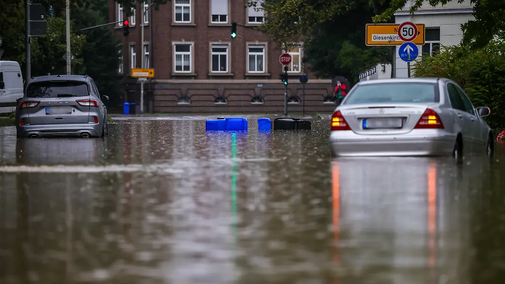 Zwei-Autos-stehen-in-den-Wassermassen-in-einer-ueberschwemmten-Strasse-in-Moenchengladbach-Rheydt