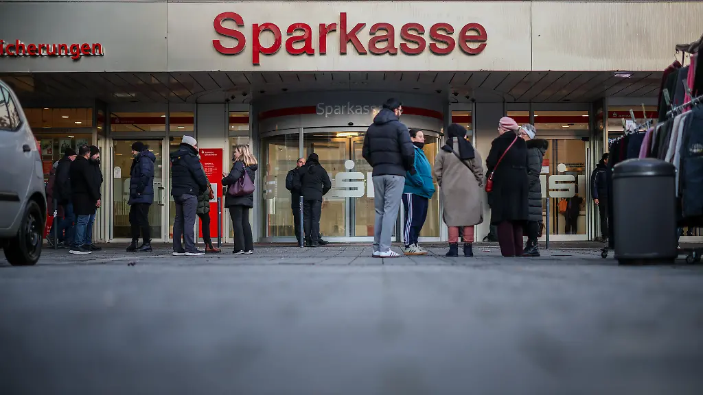 Nach-dem-Einbruch-in-den-Tresorraum-einer-Bank-stehen-am-Morgen-Kunden-vor-der-Sparkassenfiliale-Buer-und-warten-auf-die-Oeffnung-Im-Tresorraum-der-Sparkassenfiliale-sind-laut-Polizei-sehr-viele-Schliessfaecher-von-dem-Taeter-oder-den-Taetern-aufgebrochen-worden-Betroffene-sollen-nun-erste-Informationen-bekommen-koennen-sagte-ein-Sparkassen-Sprecher