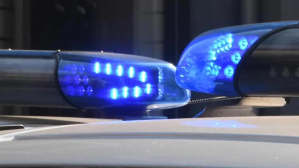 Polizeifahrzeuge-stehen-mit-eingeschaltetem-Blaulicht