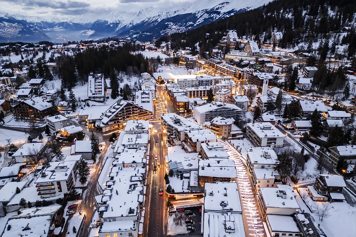 Eine-Drohnenaufnahme-des-Ferienortes-Crans-Montana-der-auf-einem-Plateau-mit-Blick-auf-das-Rhonetal-liegt-Bei-einer-Explosion-und-einem-Brand-in-der-Silvesternacht-sind-im-noblen-Schweizer-Skiort-Crans-Montana-nach-Polizeiangaben-mehrere-Menschen-ums-Leben-gekommen-Die-Tragoedie-ereignete-sich-gegen-01-30-Uhr-in-einer-Bar-in-der-mehr-als-100-Menschen-das-neue-Jahr-gefeiert-haben-sollen-Die-Polizei-bestaetigte-entsprechende-Medienberichte