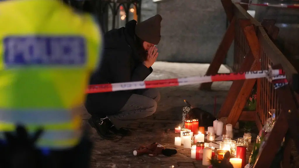 People-mourn-beside-candles-and-flowers-near-the-Le-Constellation-bar-where-a-devastating-fire-left-dead-and-injured-during-the-New-Year-s-celebrations-in-Crans-Montana-Swiss-Alps-Switzerland-Thursday-Jan-1-2026