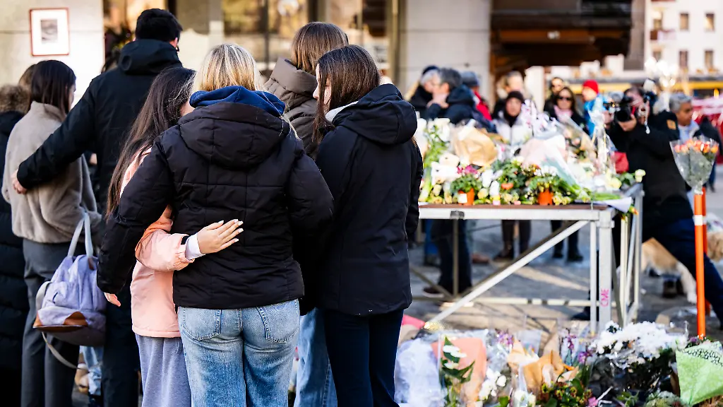 People-are-paying-their-respects-to-the-victims-with-flowers-near-the-area-where-a-unidentified-origin-fire-broke-out-at-the-Le-Constellation-bar-and-lounge-leaving-people-dead-and-injured-during-New-YearAs-celebration-in-Crans-Montana-Switzerland-Friday-January-2-2026-According-to-the-police-several-dozen-people-lost-their-lives-in-the-fire-that-devastated-the-bar-Le-Constellation-on-New-Year-s-Eve-in-the-Swiss-Alps-resort-of-Crans-Montana-Around-one-hundred-people-were-also-reported-injured