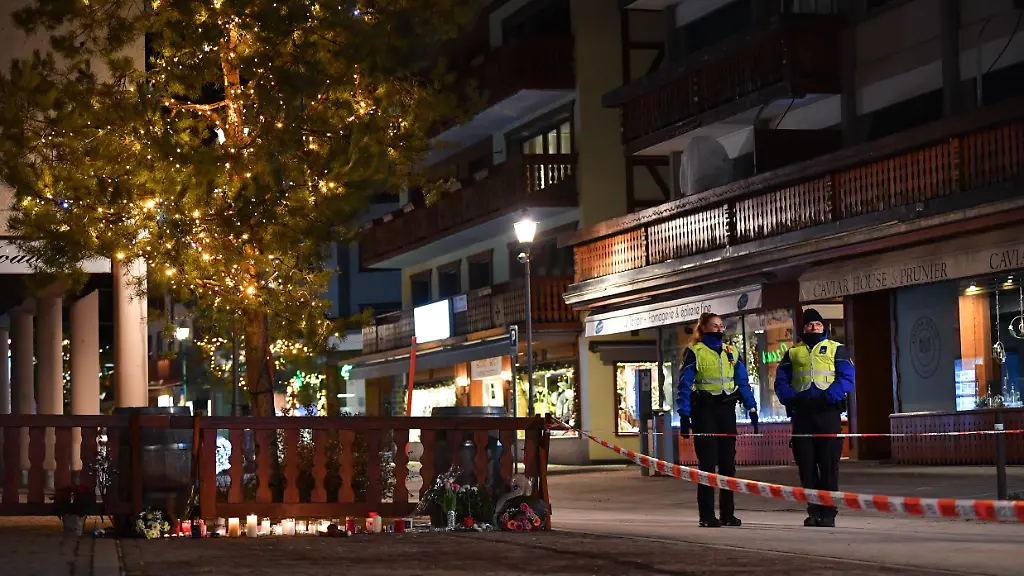 Kerzen-und-Blumen-liegen-an-einer-Absperrung-zum-Gedenken-an-die-Opfer-eines-Brandes-in-einer-Bar-im-Skigebiet-Crans-Montana-im-Kanton-Wallis-Schweiz-Bei-einem-Brand-in-einer-Bar-im-Skigebiet-Crans-Montana-im-Kanton-Wallis-in-der-Suedwestschweiz-wurden-rund-40-Menschen-getoetet-und-mehr-als-110-weitere-verletzt-wie-die-oertliche-Polizei-am-Donnerstag-mitteilte