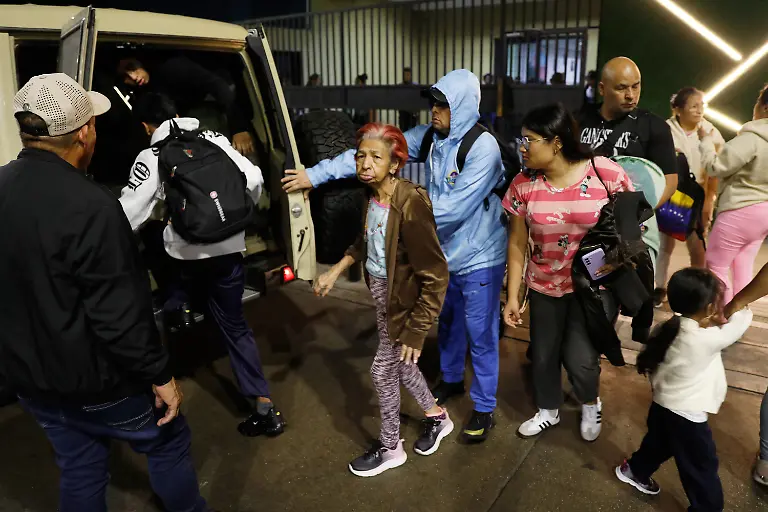 Residents-evacuate-a-building-near-the-Miraflores-presidential-palace-after-explosions-and-low-flying-aircraft-were-heard-in-Caracas-Venezuela-Saturday-Jan-3-2026
