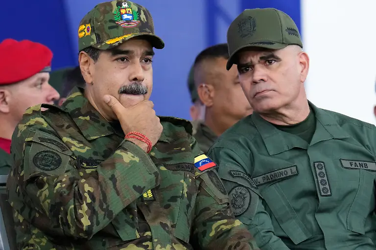 Venezuelan-President-Nicolas-Maduro-left-listens-to-Defense-Minister-Vladimir-Padrino-Lopez-during-a-government-organized-civic-military-march-in-Caracas-Venezuela-Tuesday-Nov-25-2025