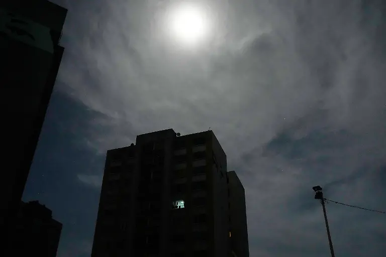 The-moon-shines-over-a-residential-area-near-Fort-Tiuna-the-main-military-garrison-in-Caracas-Venezuela-which-has-no-electricity-after-explosions-and-low-flying-aircraft-were-heard-Saturday-Jan-3-2026