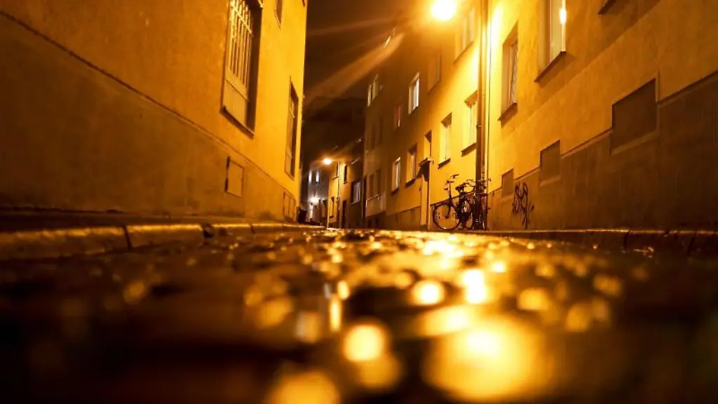 Eine-Laterne-beleuchtet-am-Abend-eine-leere-Strasse