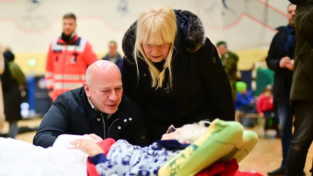 04-01-2026-Berlin-Kai-Wegner-CDU-Regierender-Buergermeister-von-Berlin-und-Iris-Spranger-SPD-Berliner-Senatorin-fuer-Inneres-und-Sport-sprechen-waehrend-eines-Stromausfalls-im-Suedwesten-Berlins-in-einer-Notunterkunft-mit-der-97-jaehrigen-Ingeborg-aus-Lichtenfelde-Zehntausende-Menschen-im-Suedwesten-der-Hauptstadt-haben-keinen-Strom-Und-das-Ganze-wird-wohl-noch-tagelang-andauern