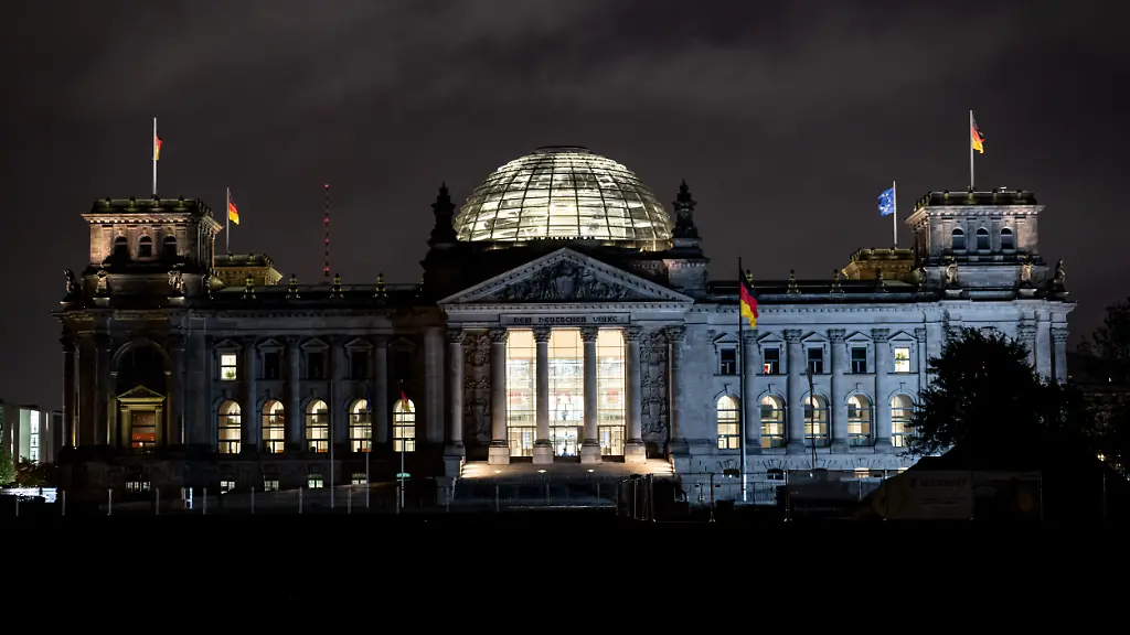 Die-Fenster-im-Reichstagsgebaeude-des-Deutschen-Bundestags-sind-am-fruehen-Morgen-in-Berlin-erleuchtet