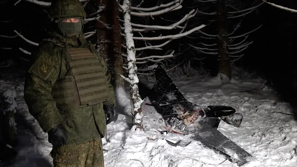 Dieses-Bild-aus-einem-undatierten-Video-das-vom-Pressedienst-des-russischen-Verteidigungsministeriums-am-31-Dezember-2025-zur-Verfuegung-gestellt-wurde-zeigt-einen-Mann-in-Tarnkleidung-der-an-einem-ungenannten-Ort-neben-einer-angeblich-abgeschossenen-Drohne-steht-bei-der-es-sich-angeblich-um-eine-der-ukrainischen-Drohnen-handelt-die-an-einem-angeblichen-Angriff-auf-eine-Residenz-von-Russlands-Praesident-Wladimir-Putin-in-dieser-Woche-beteiligt-waren-Der-ukrainische-Praesident-Selenskyj-wies-die-Anschuldigungen-zurueck