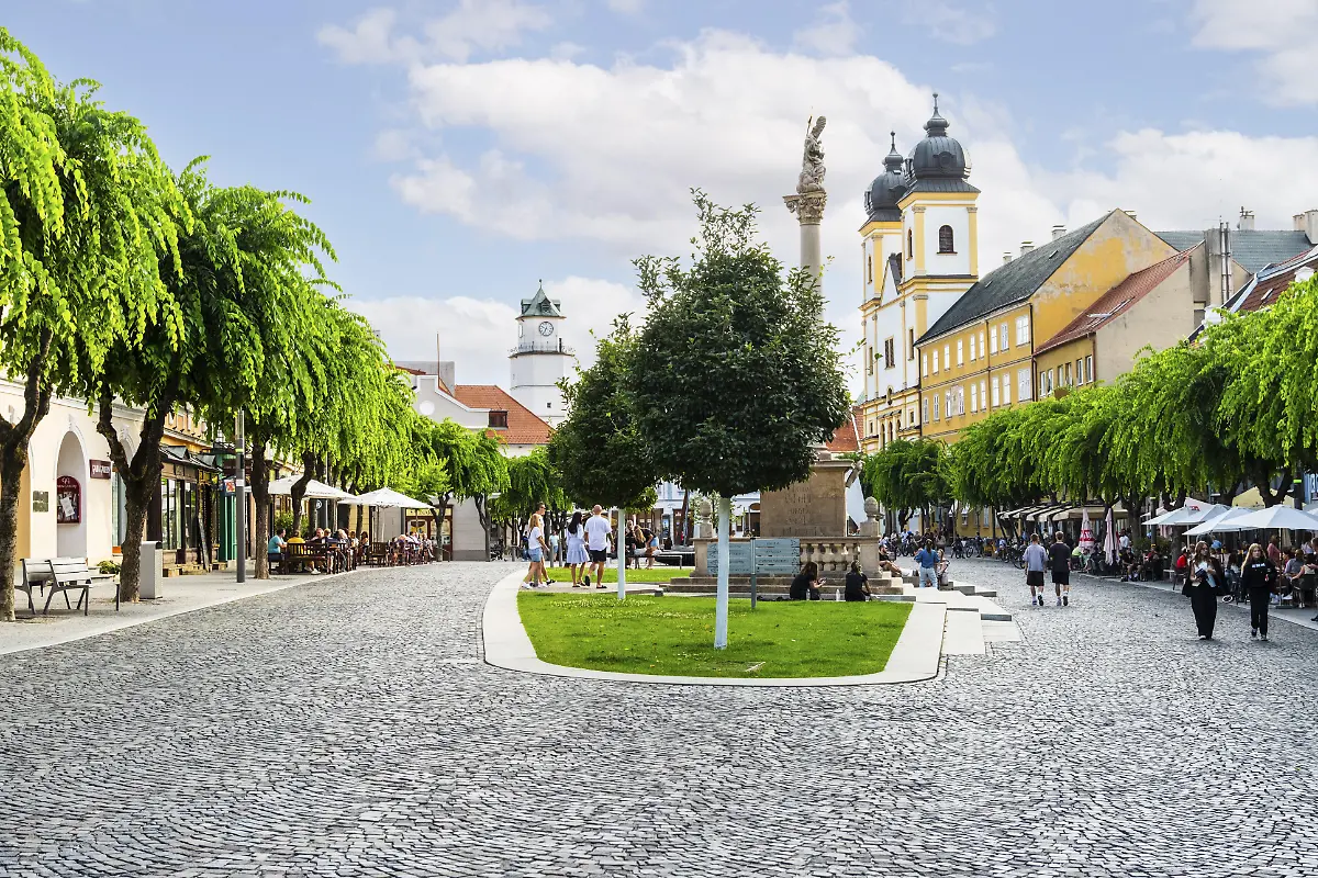 Friedensplatz-mit-Cafes-in-der-Altstadt-von-Trencin-im-Hintergrund-die-Piaristenkirche-St