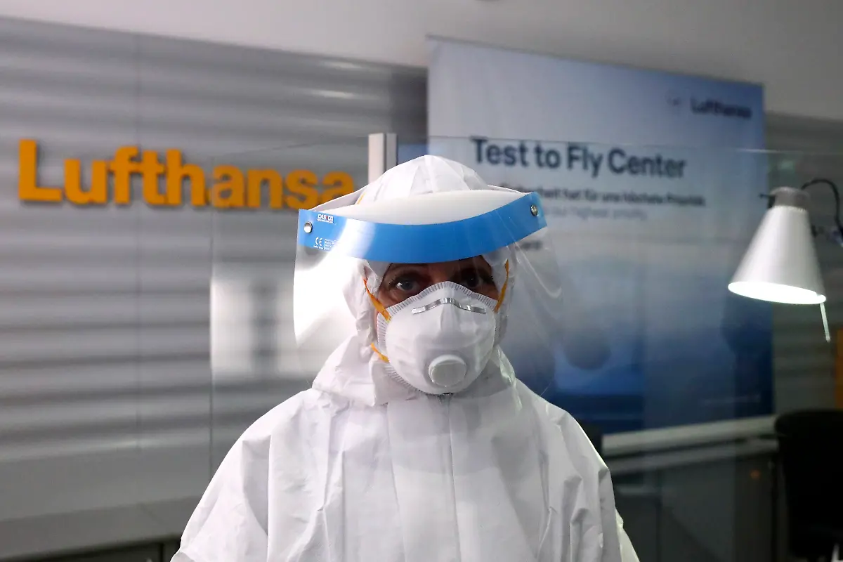 An-employee-of-a-new-Lufthansa-corona-quick-test-center-waits-for-passengers-at-the-airport-in-Munich-Germany-Thursday-Nov-12-2020-Lufthansa-starts-the-first-test-runs-for-comprehensive-Covid-19-antigen-rapid-tests-on-selected-routes-between-Munich-and-Hamburg