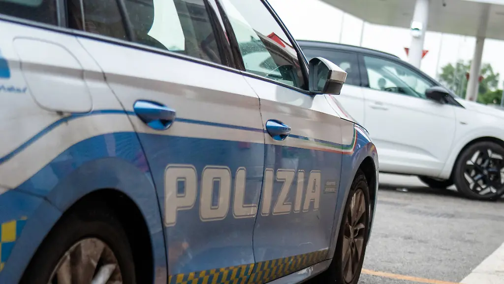 Italy-June-4-2025-A-patrol-car-of-the-Italian-highway-police-is-parked-at-a-rest-area-in-Italy-An-Esso-petrol-station-can-be-seen-in-the-background-control-or-break-situation-on-the-highway-Ein-Streifenwagen-der-italienischen-Autobahnpolizei-steht-an-einem-Rastplatz-in-Italien-Im-Hintergrund-ist-eine-Esso-Tankstelle-zu-sehen-Kontroll-oder-Pausensituation-auf-der-Fernstrasse