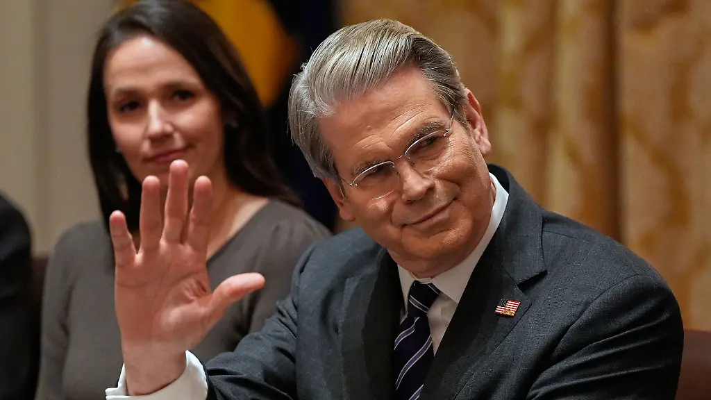 Treasury-Secretary-Scott-Bessent-waves-during-a-roundtable-meeting-with-President-Donald-Trump-on-farm-subsidies-in-the-Cabinet-Room-of-the-White-House-Monday-Dec-8-2025-in-Washington