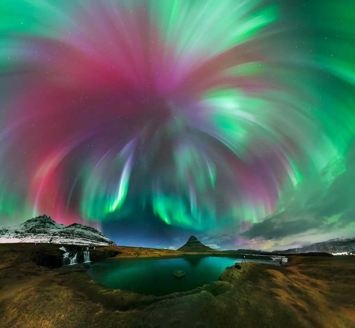 This-image-was-captured-during-the-March-Equinox-as-a-geomagnetic-storm-structure-brought-a-mesmerizing-light-show-A-full-zenith-Auroral-Corona-erupted-overhead-powerful-bright-pillars-of-light-radiated-across-the-sky-creating-a-stunning-crown-light-blast-shape-This-rare-phenomenon-occurred-on-March-21-2025-when-a-CME-struck-Earth-triggering-a-G2-geomagnetic-storm-The-shot-is-a-360-panoramic-stitch-of-21-frames-capturing-the-entire-Aurora-shape-and-a-complete-sky-view-I-used-a-Sigma-Art-fast-f-1-4-lens-to-get-a-fast-exposure-and-capture-the-pillar-structure-Kirkjufell-is-one-of-Iceland-s-most-iconic-mountains-and-witnessing-the-aurora-here-was-a-one-of-a-kind-experience-With-the-Kirkjufellsfoss-waterfalls-in-the-foreground-this-image-is-a-dynamic-representation-of-the-sweeping-auroral-corona