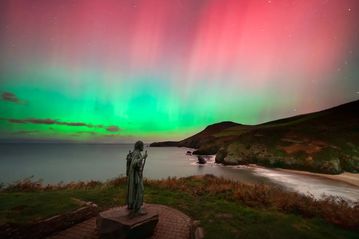 I-was-overjoyed-to-capture-this-otherworldly-Northern-Lights-display-on-the-rugged-Ceredigion-coast-of-West-Wales-The-village-of-Llangrannog-is-not-known-for-its-celestial-displays-it-is-better-known-for-its-beach-dramatic-cliffs-and-the-statue-of-St-Crannog-who-stands-watch-over-the-shoreline-Because-sightings-of-the-aurora-in-this-part-of-Wales-are-so-uncommon-this-location-lies-52-degrees-north-each-image-I-ve-captured-is-an-intersection-of-preparation-great-timing-clear-skies-and-of-course-a-bit-of-luck-The-final-image-is-a-wonderful-representation-of-this-quaint-coastal-village-and-I-love-how-all-the-elements-came-together