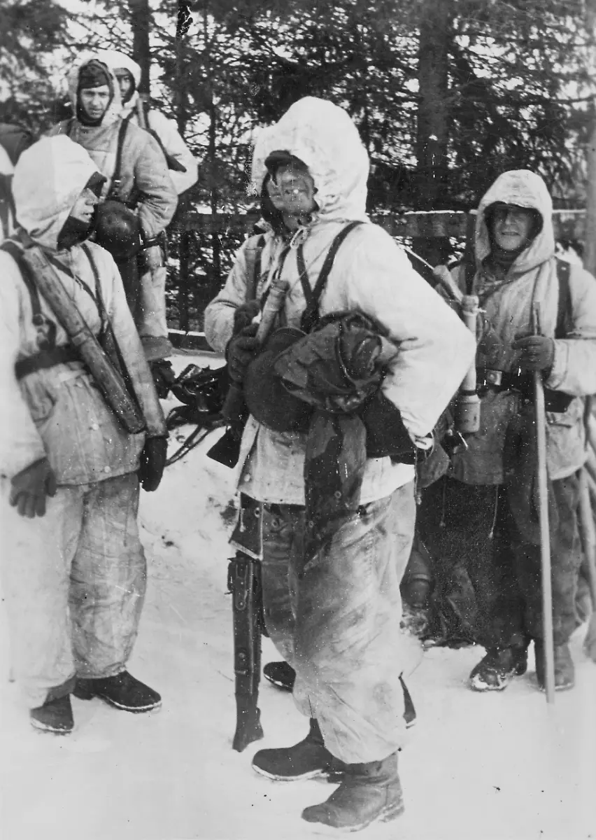 Deutsche-Soldaten-in-Winterbekleidung-an-der-Ostfront-Der-Soldat-in-der-Mitte-traegt-ein-Maschinengewehr-42-der-Soldat-links-den-Ersatzlauf