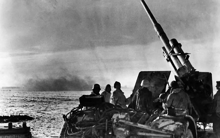 Eine-deutsche-8-8-cm-FlaK-18-36-37-genannt-Acht-Acht-eroeffnet-das-Feuer-auf-sowjetische-Schlachtflieger-Im-Hintergrund-sind-die-Einschlaege-der-russischen-Bomben-zu-erkennen