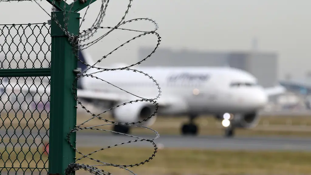 Symbolbild-zum-Thema-Abschiebeflug-Ein-Flugzeug-der-Fluggesellschaft-Lufthansa-startet-vom-Flughafen-Frankfurt-a-M-im-Vordergrund-Natodraht-Flughafen-Frankfurt-a-M-am-13-11-2025-in-Frankfurt-a-M-Deutschland