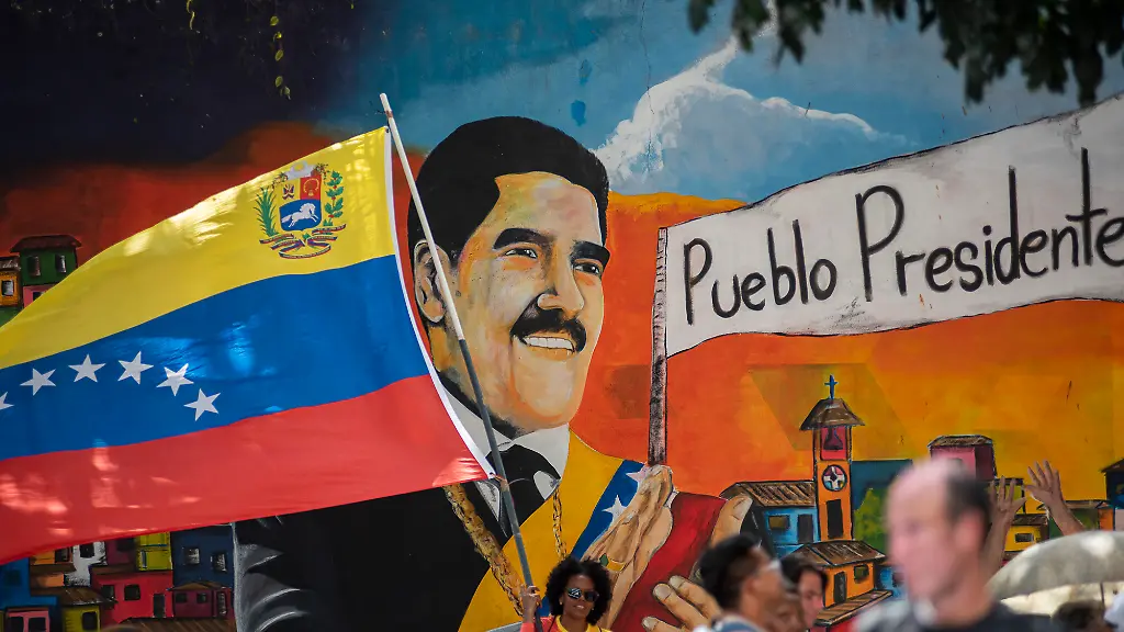 Supporters-of-ousted-Venezuela-s-President-Nicolas-Maduro-carry-his-portrait-during-a-rally-outside-the-National-Assembly-in-Caracas-Venezuela-on-Monday-on-January-5-2026-Venezuela-s-parliament-swore-in-Delcy-Rodriguez-as-interim-president-on-January-5-two-days-after-US-forces-seized-her-predecessor-Nicolas-Maduro-to-face-trial-in-New-York-Members-of-the-new-National-Assembly-offered-their-full-backing-to-Rodriguez-who-had-been-Maduro-s-vice-president-and-reelected-her-brother-Jorge-Rodriguez-as-parliament-head