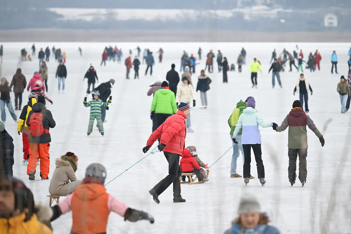 Hunderte-Menschen-tummeln-sich-auf-dem-grossteils-zugefrorenem-Gnadensee-zwischen-der-Insel-Reichenau-und-Allensbach-gegenueber-Am-Mittag-bildete-sich-ein-langer-Zug-aus-Menschen-der-am-Rand-des-Bodensees-Gnadensee-ist-ein-Teil-davon-von-einer-Seite-zur-anderen-zog