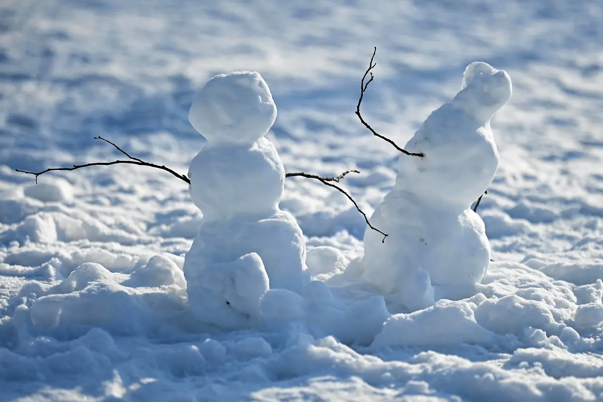 Zwei-Schneemaenner-stehen-im-Schnee-im-Georgengarten