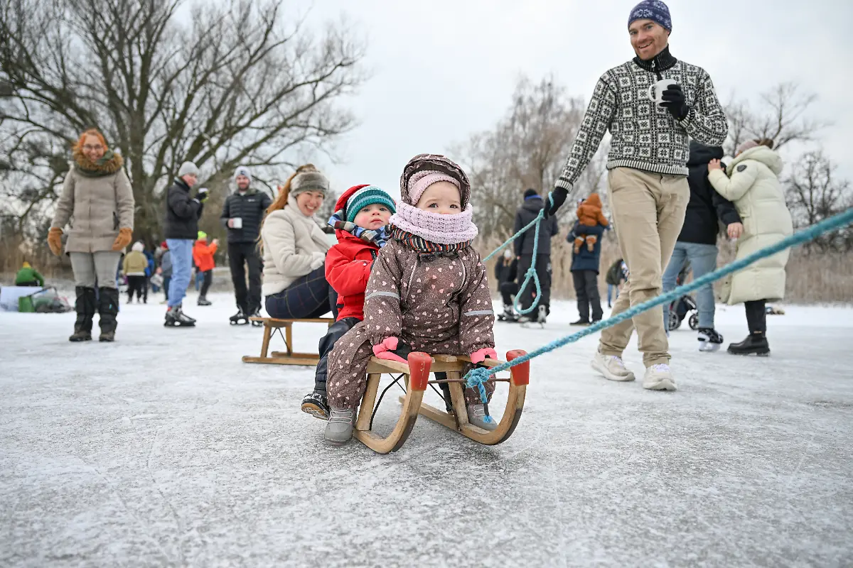Familie-Stammeijer-vorn-von-der-Insel-Reichenau-ist-mit-zwei-Schlitten-auf-dem-grossteils-zugefrorenem-Gnadensee-zwischen-der-Insel-Reichenau-und-Allensbach-unterwegs-Am-Mittag-bildete-sich-ein-langer-Zug-aus-Menschen-der-am-Rand-des-Bodensees-der-Gnadensee-ist-ein-Teil-davon-von-einer-Seite-zur-anderen-verlief