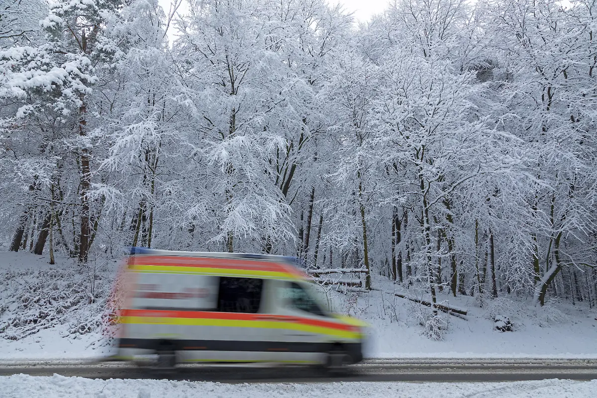 Rettungswagen-faehrt-durch-verschneite-Landschaft-Baeume-Winter-Schnee-Sieversen-Samtgemeinde-Rosengarten-Niedersachsen-Deutschland