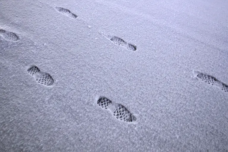 19-01-2023-Wuppertal-Wintereinbruch-in-Wuppertal-und-Umgebung-Heftige-Schneefaelle-und-Glatteis-in-der-Nacht-zum-Donnerstag-haben-fuer-starkes-Chaos-auf-den-Strassen-in-NRW-gesorgt-Fussspuren-auf-einem-rutschigen-schneebedeckten-Fussgaengerweg-Gehweg-Fussweg-Es-besteht-Raeumpflicht-Der-Winterdienst-ist-im-Dauereinsatz-um-die-Strassen-und-Wege-vom-Schnee-frei-zu-bekommen-Fussspuren-im-Schnee-Die-Raeumung-und-Streuung-bei-Schnee-und-Eisglaette-durch-den-Winterdienst-erfolgt-zum-Teil-zu-Spaet-mehrere-Busse-Bahnen-und-LKW-blieben-stecken-und-konnten-nicht-weiterfahren