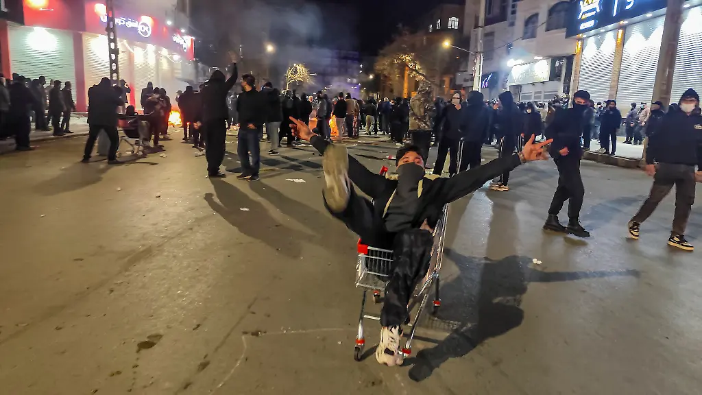 Protests-in-Iran-January-8-Iranians-gather-while-blocking-a-street-during-a-protest-in-Kermanshah-Iran-on-January-8-2026-The-nationwide-protests-started-in-Tehran-s-Grand-Bazaar-against-the-failing-economic-policies-in-late-December-which-spread-to-universities-and-other-cities-and-included-economic-slogans-to-political-and-anti-government-ones