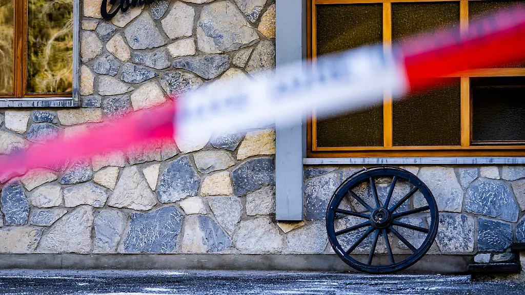 Ein-Absperrband-der-Polizei-vor-dem-Bereich-in-dem-in-der-Bar-und-Lounge-Le-Constellation-nach-einer-Explosion-in-den-fruehen-Morgenstunden-der-Silvesternacht-ein-Feuer-ausgebrochen-ist-Bei-einer-Explosion-und-einem-Brand-in-der-Silvesternacht-sind-im-noblen-Schweizer-Skiort-Crans-Montana-nach-Polizeiangaben-mehrere-Menschen-ums-Leben-gekommen-Zwischen-2020-und-2025-fanden-in-der-Bar-keine-der-ueblichen-Brandschutzkontrollen-statt