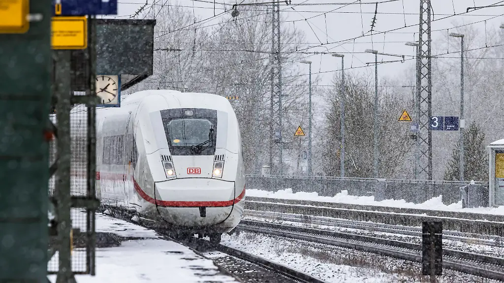 ICE-unterwegs-bei-Schneefall-durch-eine-Winterlandschaft-Ein-Zug-auf-der-Strecke-im-Schienennetz-der-Deutsche-Bahn-AG-10-01
