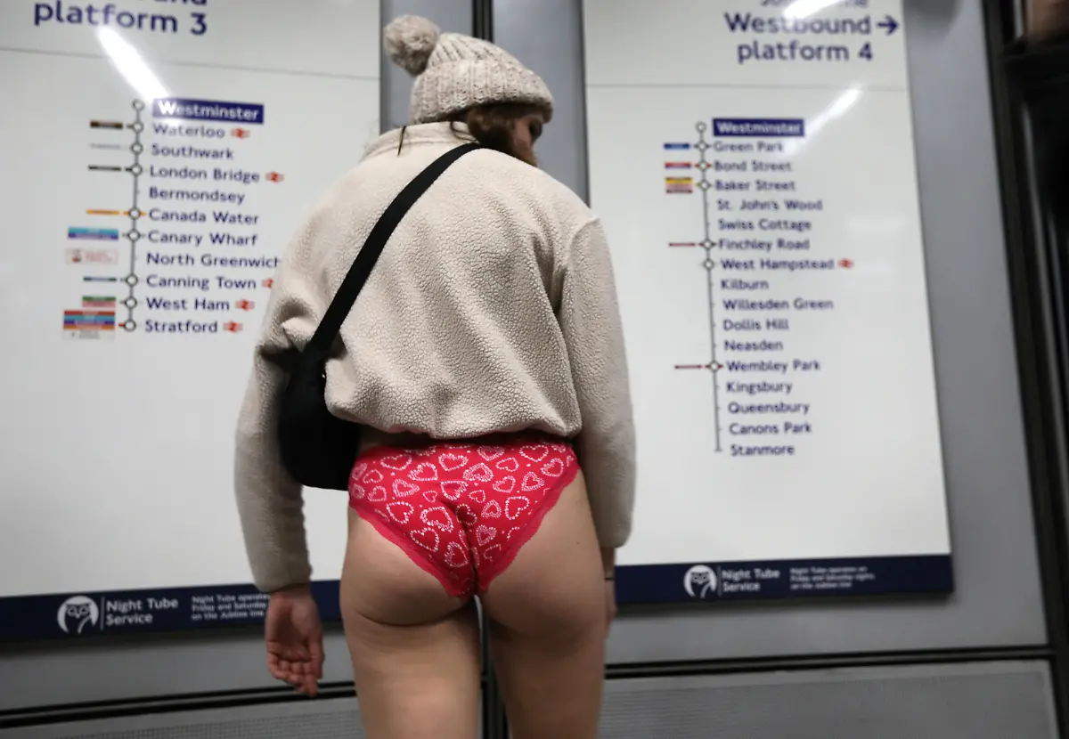 January-12-2025-London-England-United-Kingdom-A-woman-traveller-wearing-no-trousers-checks-the-route-out-of-Westminster-Those-participating-in-this-annual-event-do-for-no-reason-other-than-to-have-fun-They-gather-go-onto-the-London-Underground-system-remove-their-trousers-and-ride-around-the-system-for-a-bit-The-tradition-started-in-New-York-in-2002-the-whole-point-is-to-remain-as-nonchalant-as-possible-despite-the-fact-that-participants-have-no-trousers-on