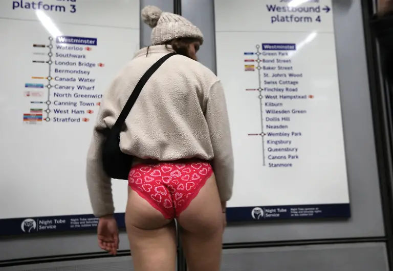 January-12-2025-London-England-United-Kingdom-A-woman-traveller-wearing-no-trousers-checks-the-route-out-of-Westminster-Those-participating-in-this-annual-event-do-for-no-reason-other-than-to-have-fun-They-gather-go-onto-the-London-Underground-system-remove-their-trousers-and-ride-around-the-system-for-a-bit-The-tradition-started-in-New-York-in-2002-the-whole-point-is-to-remain-as-nonchalant-as-possible-despite-the-fact-that-participants-have-no-trousers-on
