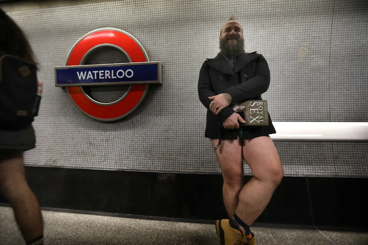 January-12-2025-London-England-United-Kingdom-A-traveller-with-a-book-waits-on-the-platform-for-a-train-at-Waterloo-Those-participating-in-this-annual-event-do-for-no-reason-other-than-to-have-fun-They-gather-go-onto-the-London-Underground-system-remove-their-trousers-and-ride-around-the-system-for-a-bit-The-tradition-started-in-New-York-in-2002-the-whole-point-is-to-remain-as-nonchalant-as-possible-despite-the-fact-that-participants-have-no-trousers-on