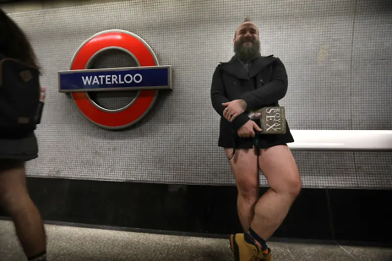 January-12-2025-London-England-United-Kingdom-A-traveller-with-a-book-waits-on-the-platform-for-a-train-at-Waterloo-Those-participating-in-this-annual-event-do-for-no-reason-other-than-to-have-fun-They-gather-go-onto-the-London-Underground-system-remove-their-trousers-and-ride-around-the-system-for-a-bit-The-tradition-started-in-New-York-in-2002-the-whole-point-is-to-remain-as-nonchalant-as-possible-despite-the-fact-that-participants-have-no-trousers-on