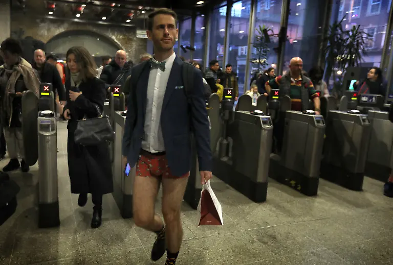 January-12-2025-London-England-United-Kingdom-A-traveller-wearing-no-trousers-emerges-from-Waterloo-underground-Those-participating-in-this-annual-event-do-for-no-reason-other-than-to-have-fun-They-gather-go-onto-the-London-Underground-system-remove-their-trousers-and-ride-around-the-system-for-a-bit-The-tradition-started-in-New-York-in-2002-the-whole-point-is-to-remain-as-nonchalant-as-possible-despite-the-fact-that-participants-have-no-trousers-on