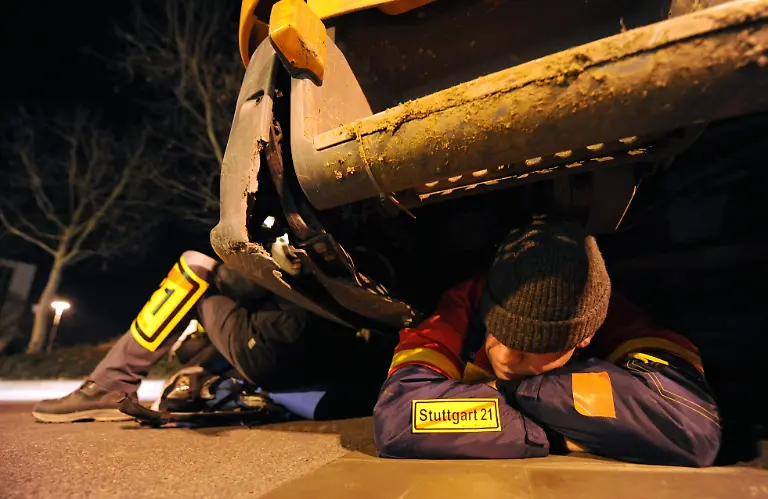 Gegner-des-Bahnprojekts-Stuttgart-21-blockieren-am-Dienstagmorgen-08-02-2011-in-Stuttgart-am-Nordfluegel-des-Hauptbahnhofs-ein-Baufahrzeug-Unter-Polizeischutz-und-dem-wuetenden-Protest-mehrerer-hundert-Demonstranten-sind-am-Dienstagmorgen-die-Bauarbeiten-fuer-das-umstrittene-Bahnprojekt-Stuttgart-21-fortgesetzt-worden