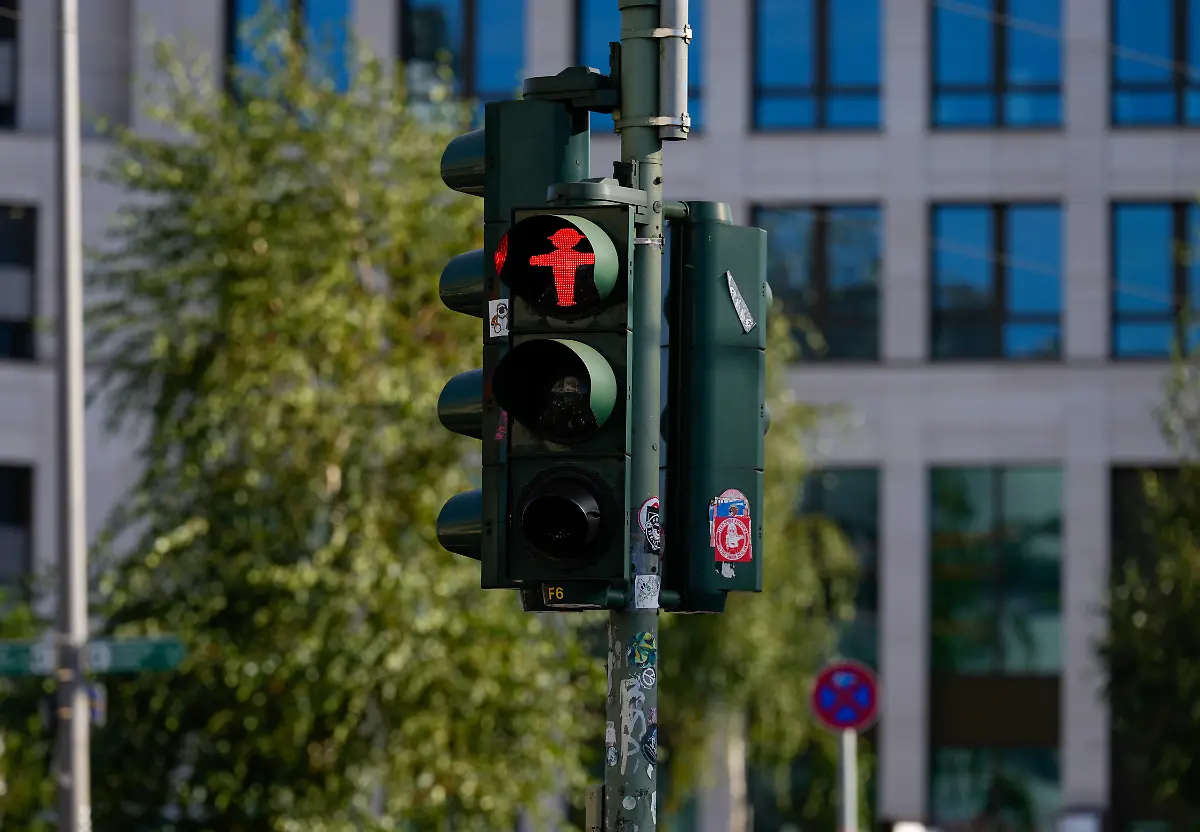 Ein-rotes-Ampelmaennchen-zeigt-Stopp-an-einer-Fussgaengerampel-Themenfoto-Rossmann-Geschaeftsschild-29-10