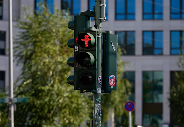 Ein-rotes-Ampelmaennchen-zeigt-Stopp-an-einer-Fussgaengerampel-Themenfoto-Rossmann-Geschaeftsschild-29-10