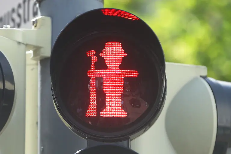Ein-rotes-Ampelmaennchen-an-einer-Ampel-haelt-ein-Gewehr-Zum-Schuetzenfest-am-kommenden-Wochenende-24-bis-27-August-sollen-in-Neuss-jetzt-neue-Ampelmaennchen-den-Weg-ueber-die-Strasse-regeln-Wie-die-Stadt-mitteilt-werden-an-insgesamt-acht-Ampeln-rote-und-gruene-Schuetzenmaennchen-aufleuchten-Mit-Hilfe-von-Schablonen-wurden-die-neuen-Umrisse-angebracht