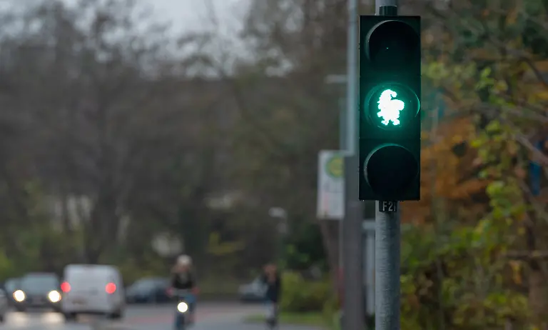 Eine-Fussgaengerampel-steht-mit-einem-Abbild-des-Weihnachtsmannes-als-Ampelmaennchen-Die-Stadt-Lueneburg-hat-an-einer-Fussgaengerampel-das-Ampelmaennchen-auf-Weihnachten-getrimmt