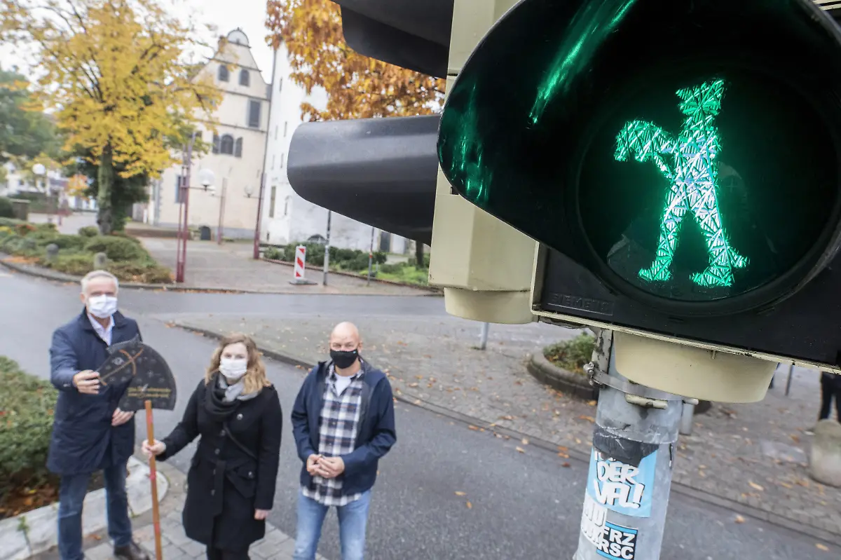 HANDOUT-Wolfgang-Griesert-l-r-Oberbuergermeister-Janin-Arntzen-Grafikdesignerin-und-Stefan-Zimmermann-Fachdienst-Verkehrsanlagen-stehen-neben-der-neuen-Steckenpferdreiter-Ampel-am-Fussgaengerueberweg-an-der-Alten-Muenze-Die-Steckenpferdreiter-gehoeren-seit-Jahrzehnten-zur-Tradition-in-Osnabrueck-Nun-bekommt-die-Stadt-an-einer-Fussgaengerueberfuehrung-in-der-Innenstadt-eine-Ampel-mit-einem-stehenden-und-einem-gehenden-Steckenpferdreiter-als-Symbol