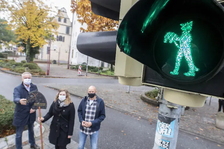 HANDOUT-Wolfgang-Griesert-l-r-Oberbuergermeister-Janin-Arntzen-Grafikdesignerin-und-Stefan-Zimmermann-Fachdienst-Verkehrsanlagen-stehen-neben-der-neuen-Steckenpferdreiter-Ampel-am-Fussgaengerueberweg-an-der-Alten-Muenze-Die-Steckenpferdreiter-gehoeren-seit-Jahrzehnten-zur-Tradition-in-Osnabrueck-Nun-bekommt-die-Stadt-an-einer-Fussgaengerueberfuehrung-in-der-Innenstadt-eine-Ampel-mit-einem-stehenden-und-einem-gehenden-Steckenpferdreiter-als-Symbol