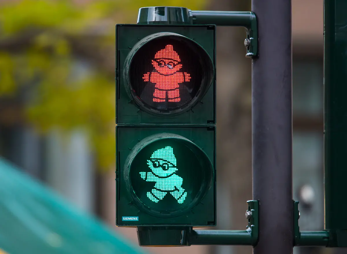 Durch-den-Nachleucht-Effekt-waehrend-des-Wechsels-von-Rot-auf-Gruen-sind-bei-dieser-Aufnahme-am-23-11-2016-in-Mainz-Rheinland-Pfalz-beide-Mainzel-Ampelmaennchen-sichtbar-Die-bundesweit-erste-Mainzelmaennchen-Ampel-ist-in-Mainz-in-Betrieb-gegangen-Die-Mainzelmaennchen-sind-sechs-Trickfiguren-namens-Anton-Berti-Conni-Det-Edi-und-Fritzchen-die-beim-Fernsehsender-ZDF-vor-allem-als-Werbetrenner-eingesetzt-werden-zu-dpa-Erste-Ampel-mit-Mainzelmaennchen-in-Betrieb-vom-23-11