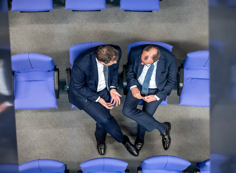 Lars-Klingbeil-l-SPD-Fraktionschef-und-Bundesvorsitzender-spricht-mit-Friedrich-Merz-CDU-CSU-Fraktionsvorsitzender-und-CDU-Bundesvorsitzender-in-den-hinteren-Sitzreihen-der-Union-waehrend-der-213-Plenarsitzung-der-20-Legislaturperiode-im-Deutschen-Bundestag-In-dieser-und-einer-noch-folgenden-Sondersitzung-des-alten-Bundestages-sollen-nach-dem-Willen-von-Union-und-SPD-ein-milliardenschweres-Sondervermoegen-und-eine-Reform-der-im-Grundgesetz-verankerten-Schuldenbremse-beschlossen-werden-Ziel-sind-Investitionen-in-Infrastruktur-und-Verteidigung